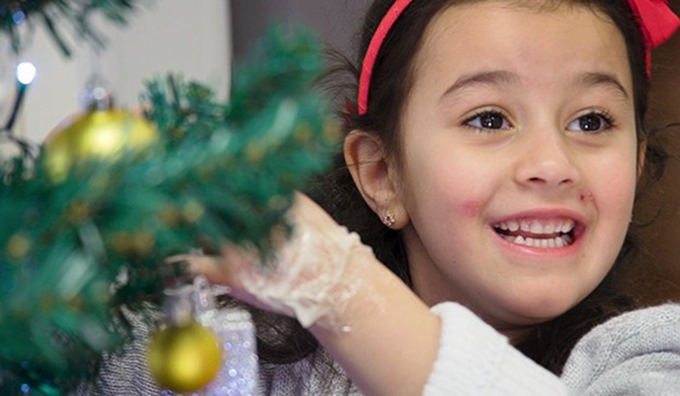 A young girl decorates a Christmas tree on the children's ward at St Mary's Hospital