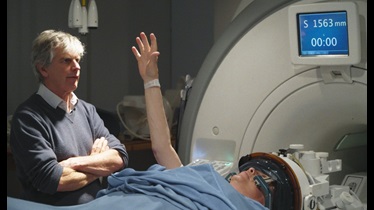 Photo of Lord Fellowes receiving treatment, overseen by Dr Peter Bain