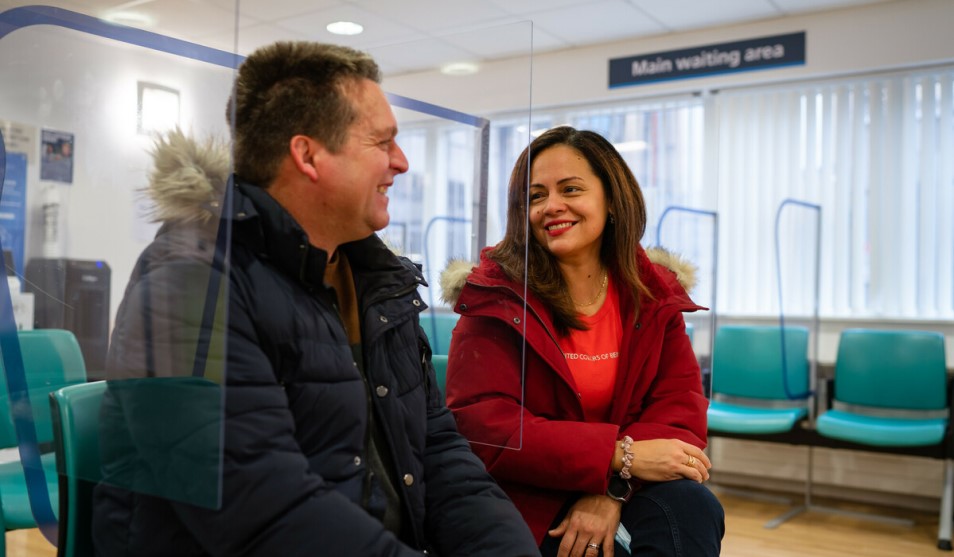 two patients sit on chairs in a main waiting area