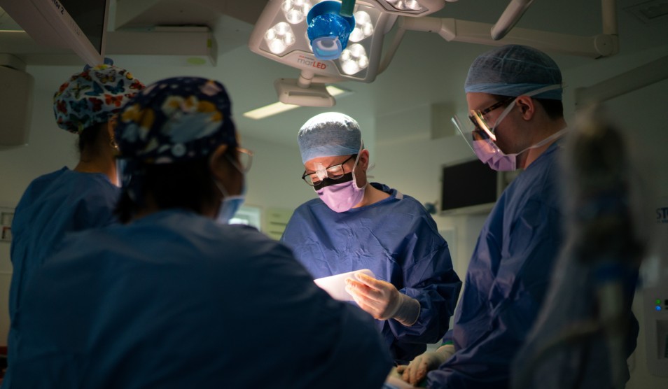 Staff in blue scrubs during a medical procedure