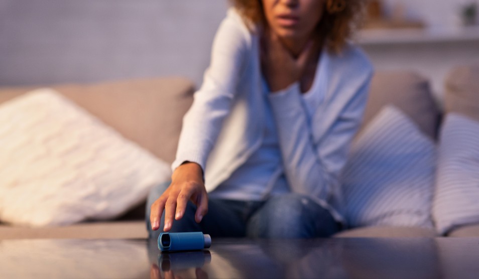Woman reaching for asthma inhaler