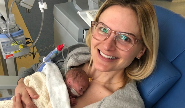 Photo of former patients Ashley and Michael. Ashley is Michael's mother and can be seen cradling a newborn and premature Michael to her chest.