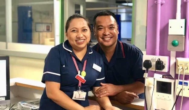 Nurses Brenda and Ralph Deocampo pose in their uniforms on a ward at Charing Cross Hospital, where they met 20 years ago. 