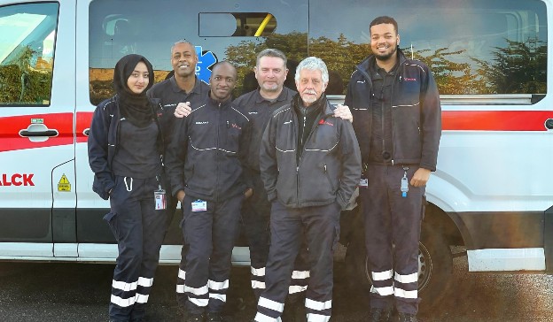 Falck UK Ambulance Service staff pose with an ambulance