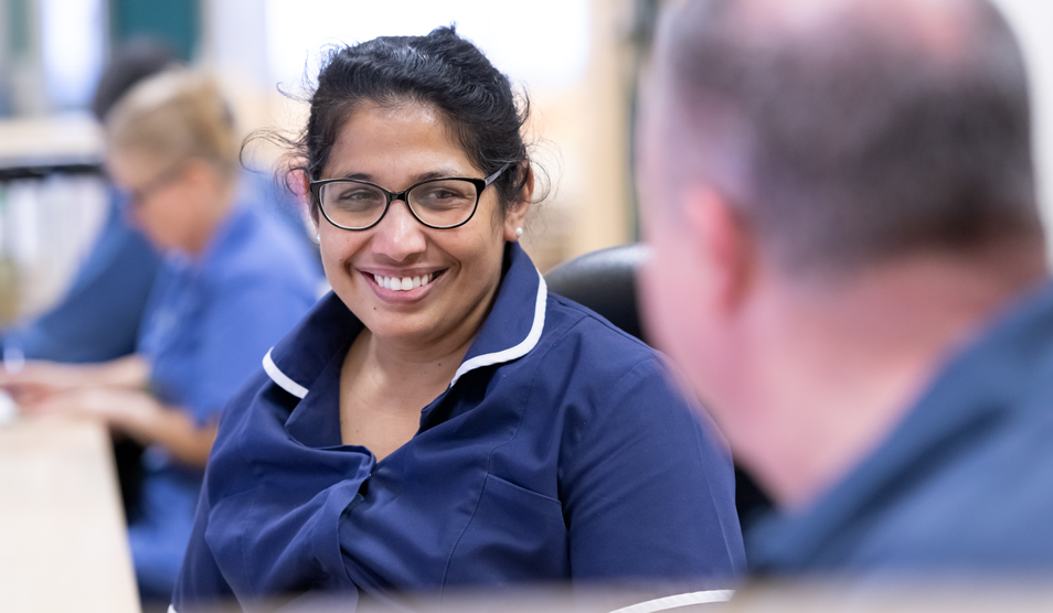 Portrait of  nurse sharing a laugh with colleagues while on her shift