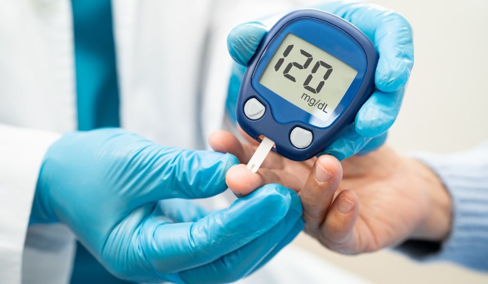 A health professional taking an insulin reading using a finger prick test