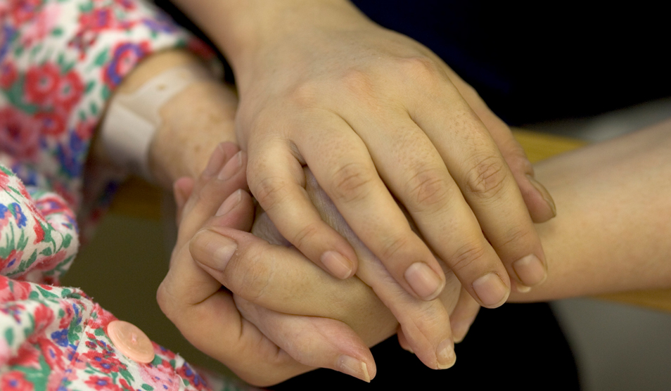 Nurse-holding-woman's-hand