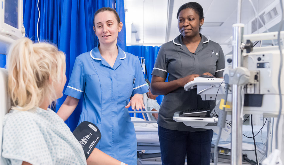 Image of woman having blood pressure taken by nurse