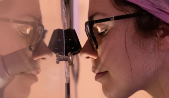 Female researcher looking through microscope
