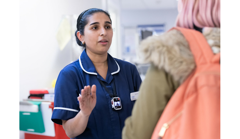 Nurse speaks with a member of the public while sporting a Body Worn Camera (BWC) Nurse speaks with a member of the public while sporting a Body Worn Camera (BWC)