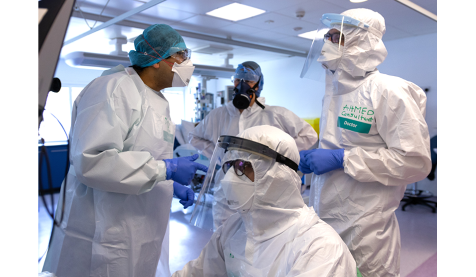 Photo of four clinicians wearing PPE Photo of four clinicians wearing PPE