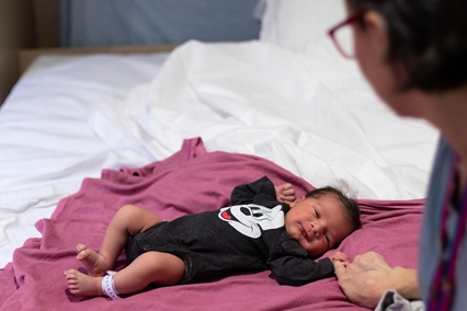 midwife holding baby's hand.