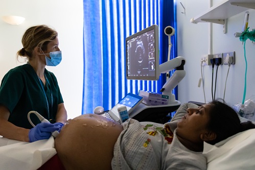 sonographer giving an ultrasound scan to a pregnant person